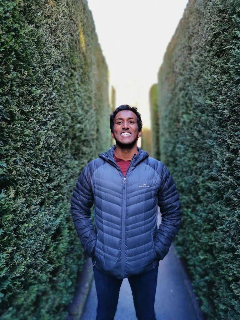 Shanaka Jayakody standing in a hedge maze